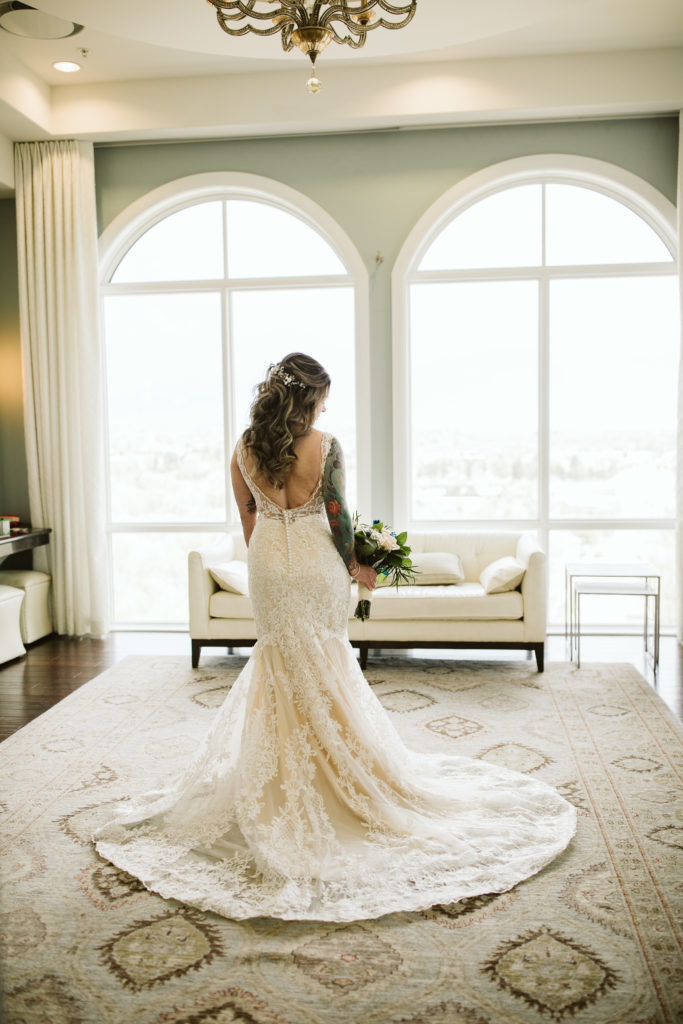 bride in wedding gown posed at window