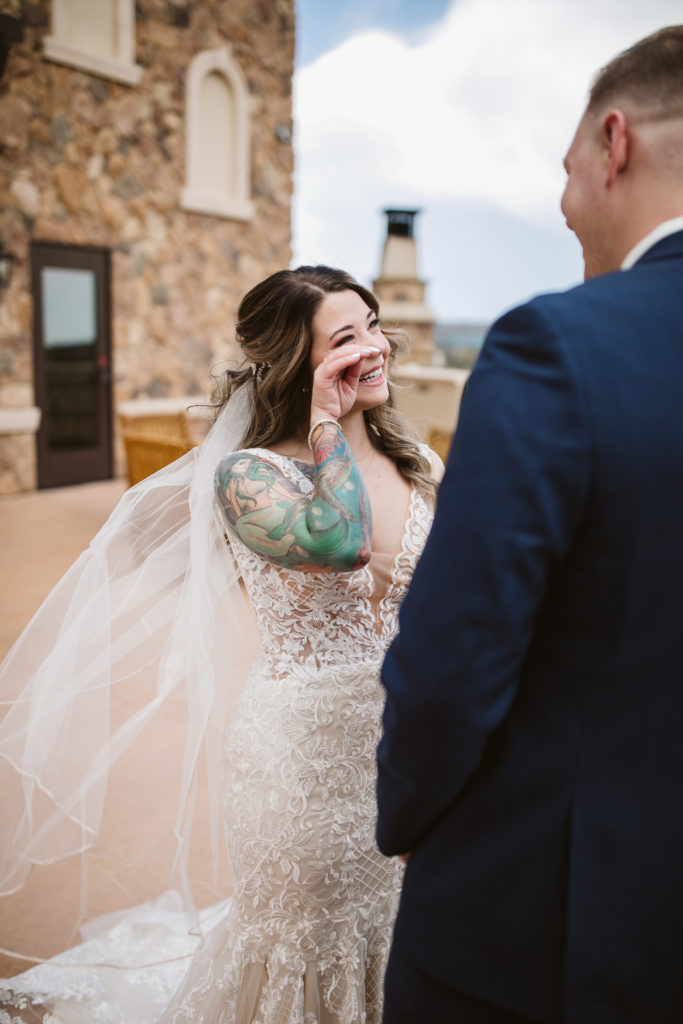 outdoor first look bride wipes away tears smiling